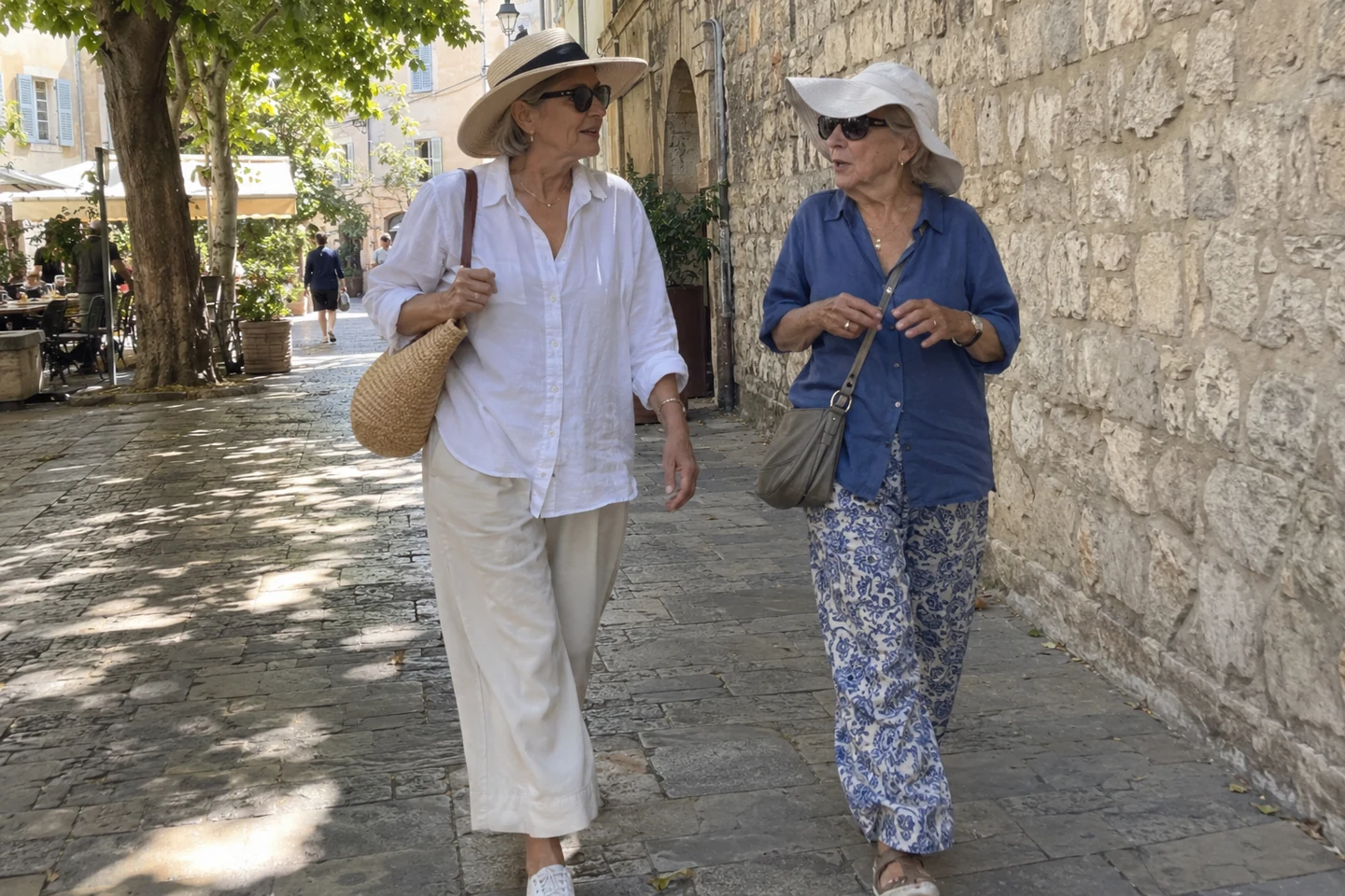 Deux femmes marchent à l’ombre, avec des chapeaux et des vêtements couvrants