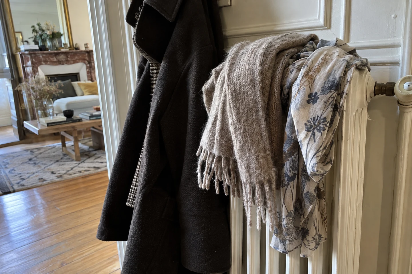 Deux écharpes aux textures différentes sont suspendues près d’un manteau