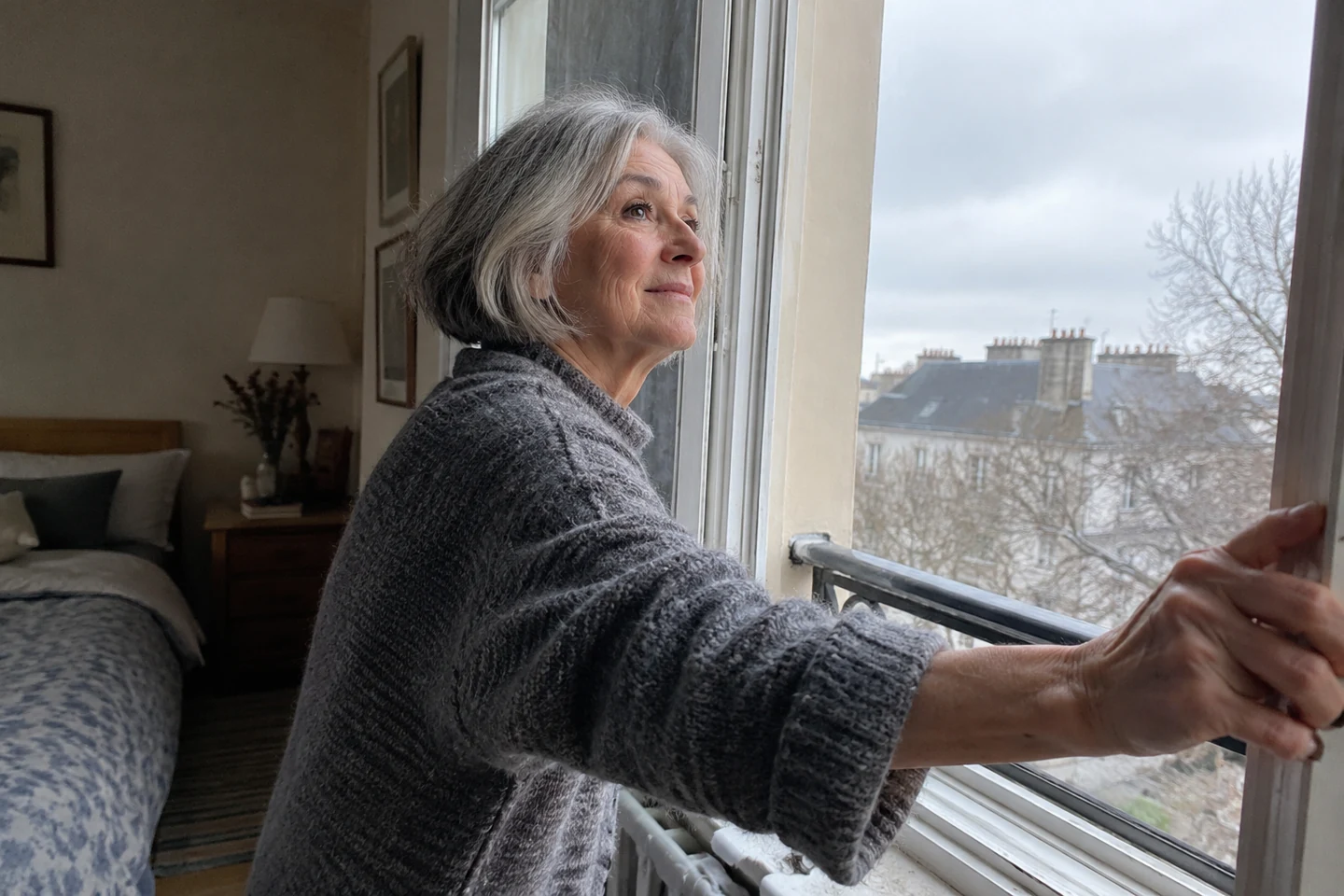 Une femme ouvre brièvement sa fenêtre lors d’une matinée froide