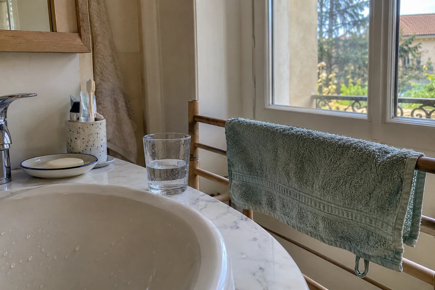 Une serviette sèche dépliée près d’une fenêtre de salle de bain