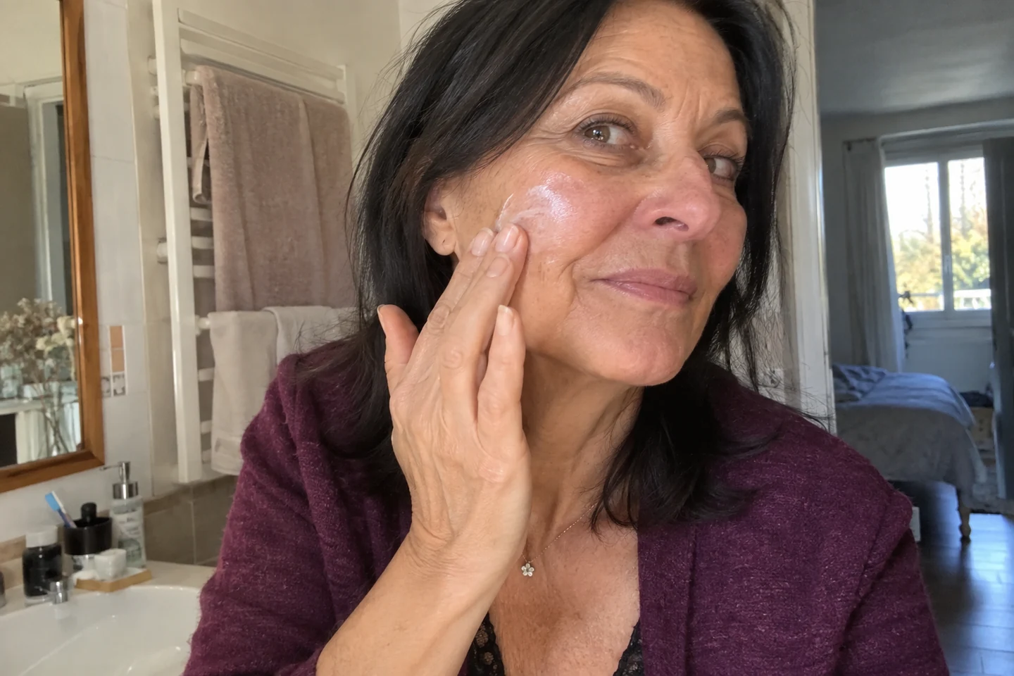 Application douce d’un soin sur le visage en lumière naturelle