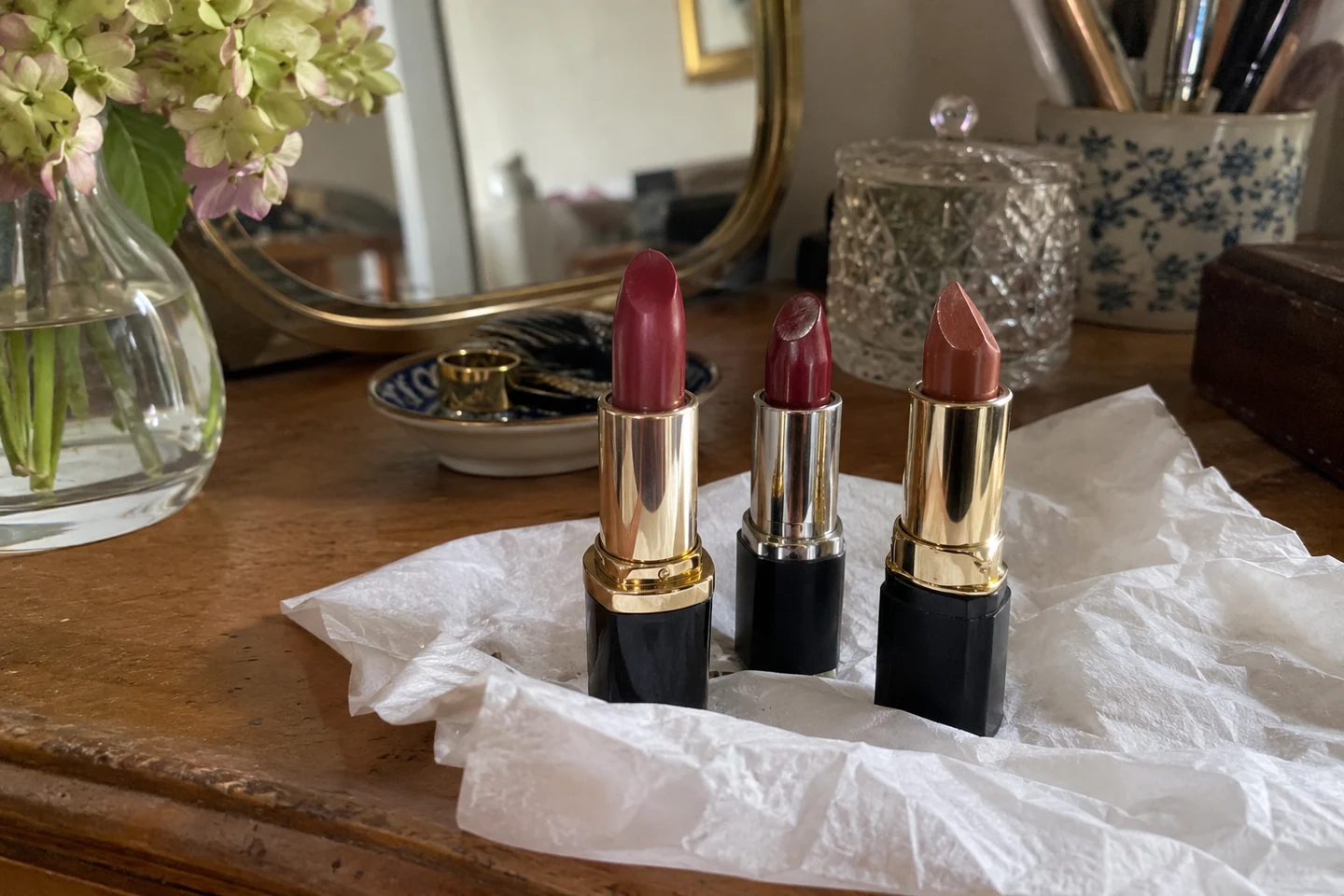 Trois rouges à lèvres rose, baie et brun sur un mouchoir