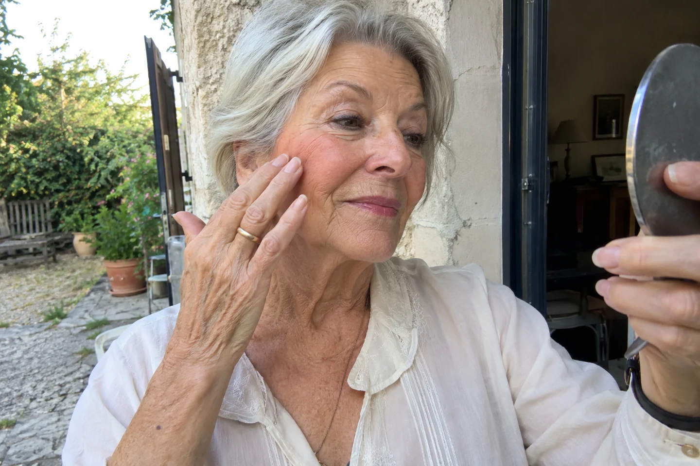 Une femme vérifie le placement de son blush dans un petit miroir