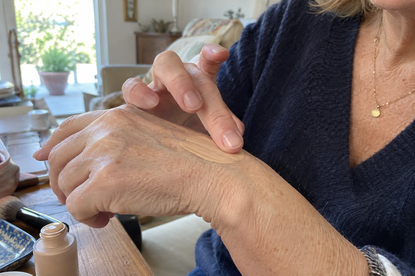 Une femme étale une petite quantité de fond de teint sur sa main