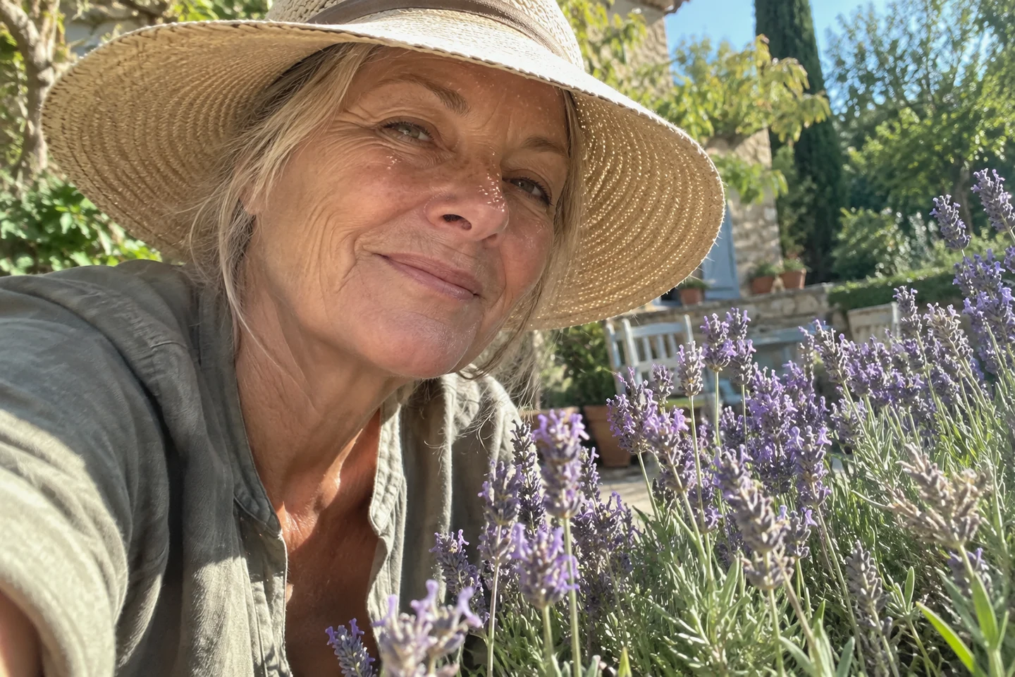 Le bord d’un chapeau ombrage le visage d’une femme près de la lavande