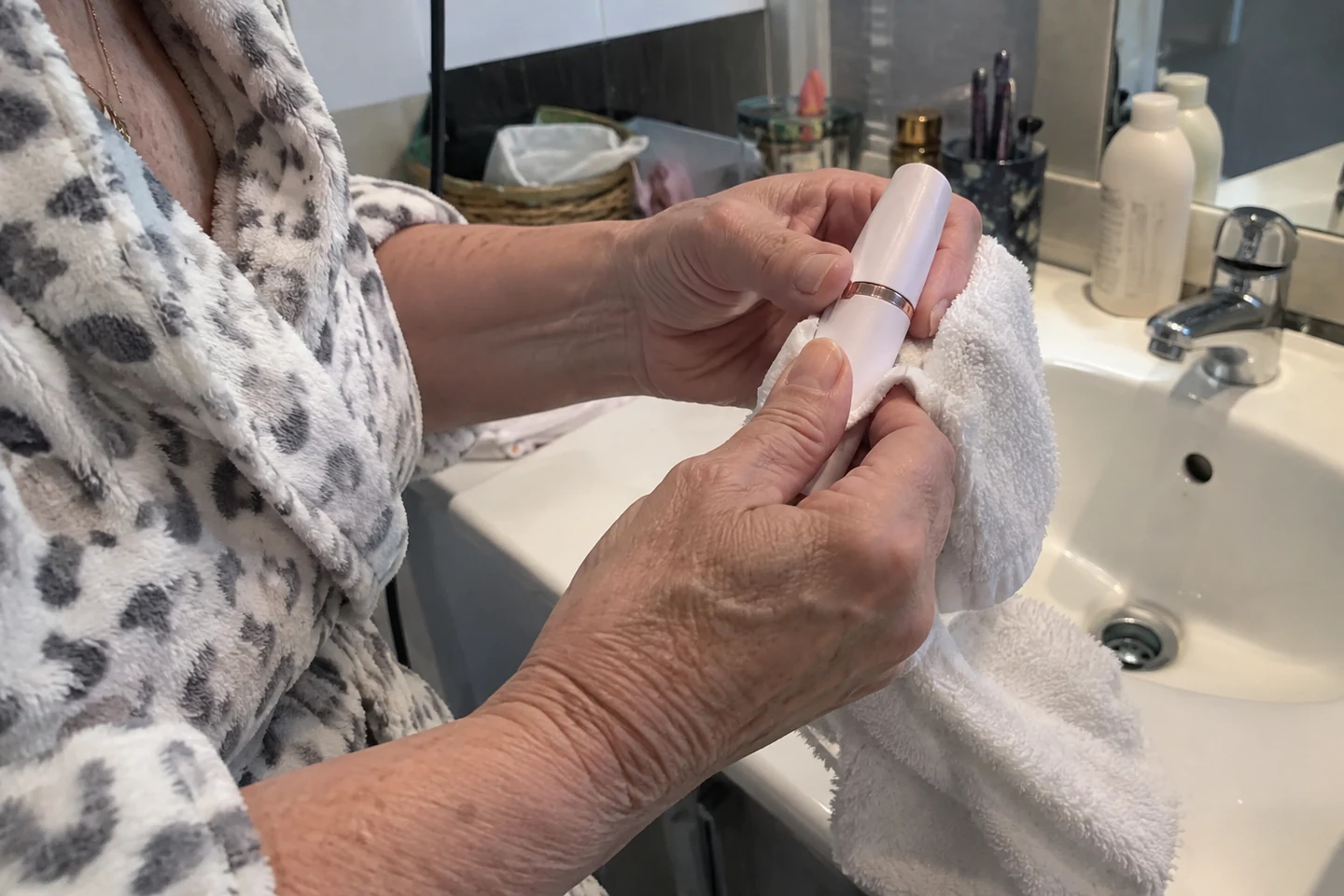 Une femme tient un appareil de soin au-dessus d’une serviette propre