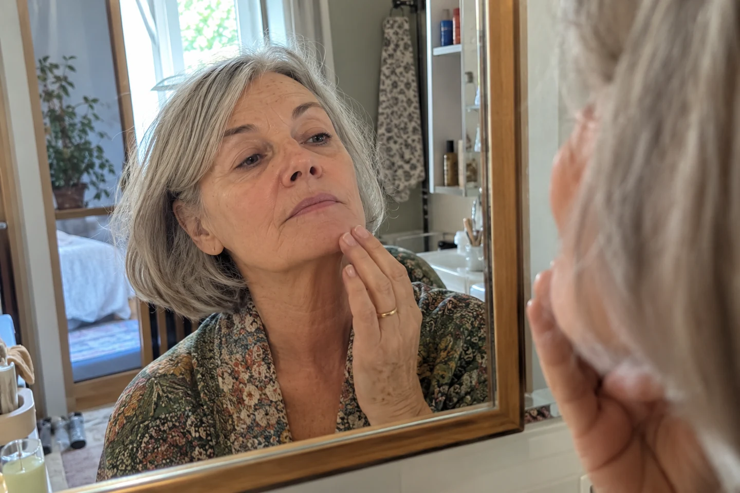 Une femme observe son menton à distance normale devant un miroir