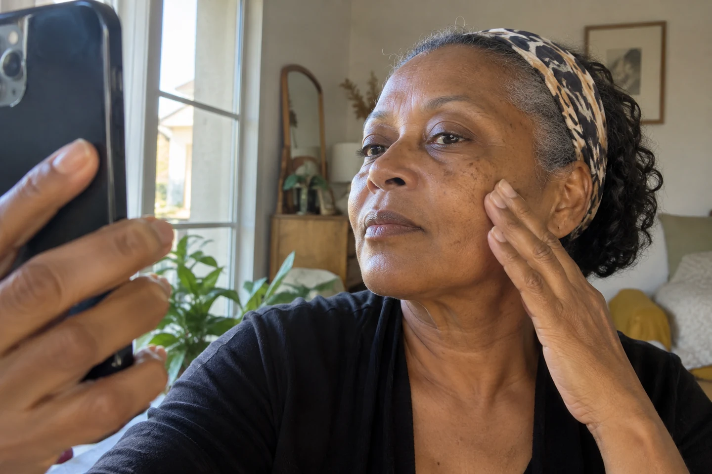 Une femme photographie une zone de sa joue avec son téléphone