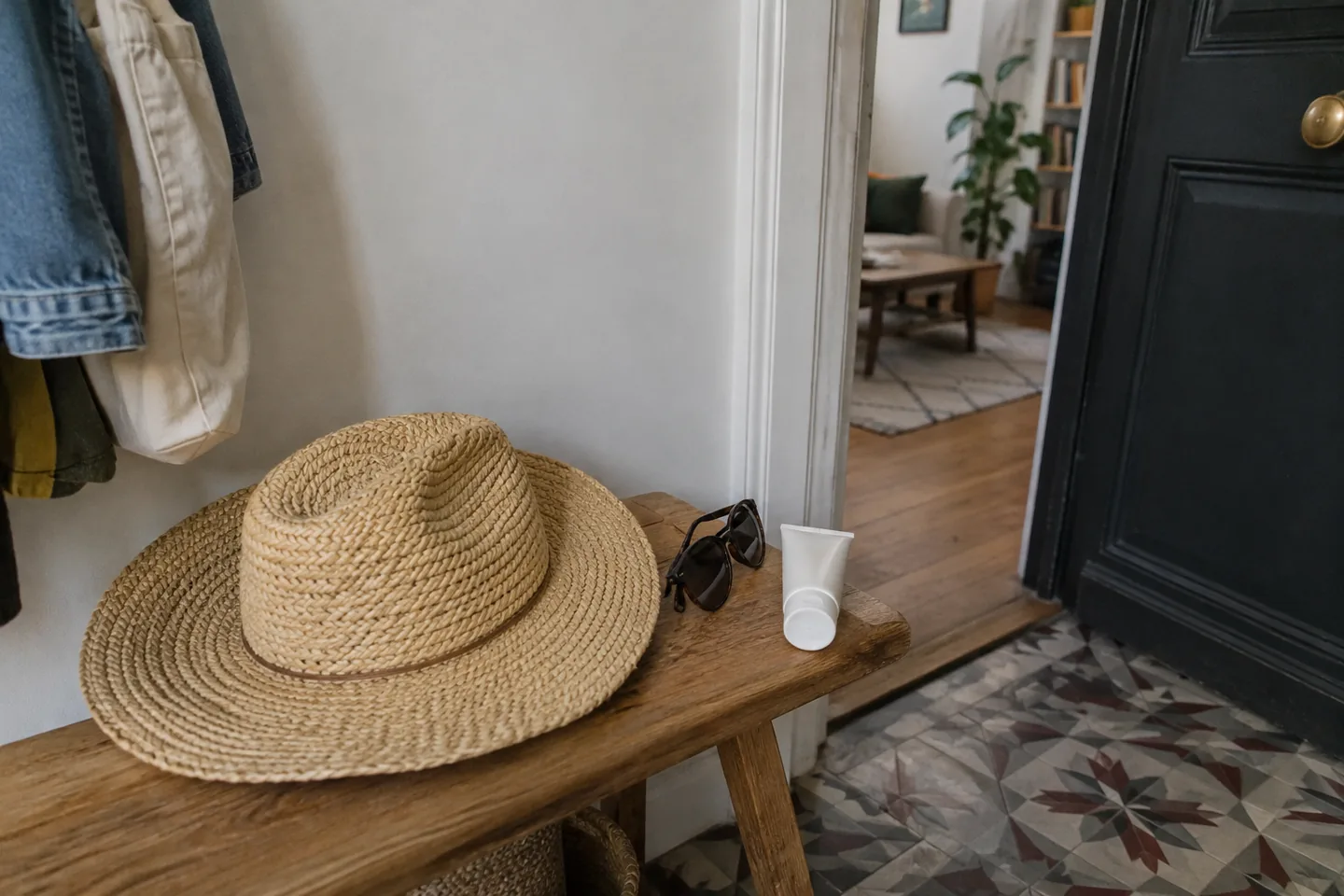 Chapeau, lunettes et tube neutre posés près d’une porte