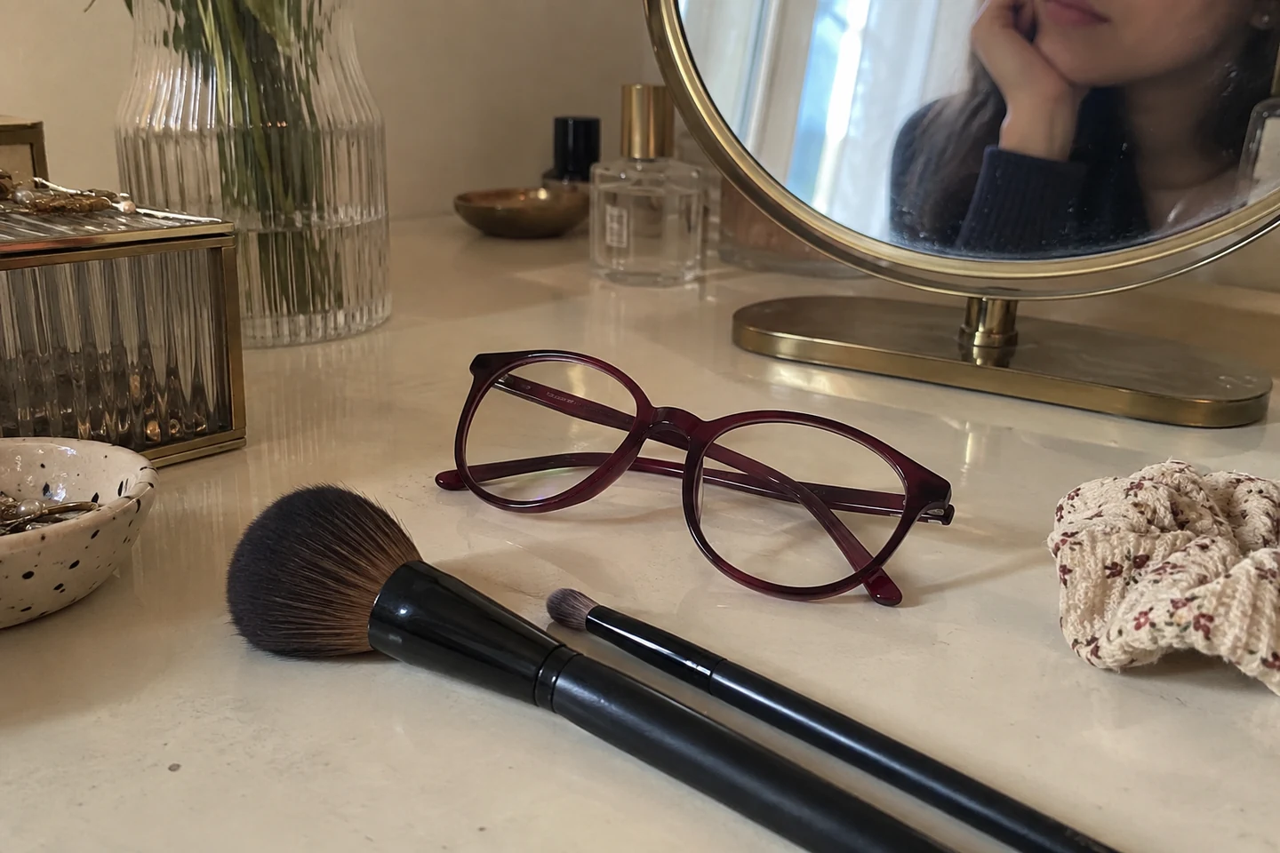 Lunettes et pinceaux sur une coiffeuse